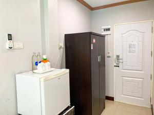 een kamer met een koelkast naast een deur bij โรงแรม ทรี บริดจ์ โฮเทล in Nan