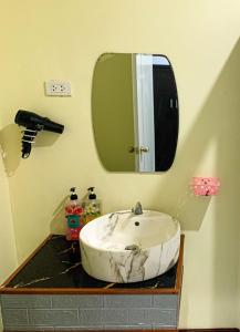 uma casa de banho com um lavatório e um espelho em โรงแรม ทรี บริดจ์ โฮเทล em Nan
