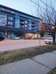 a street with cars parked in front of a building at Llt Fraser HomeAway in Vancouver