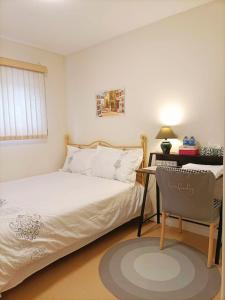 1 dormitorio con 1 cama, 1 silla y 1 mesa en Llt Fraser HomeAway en Vancouver