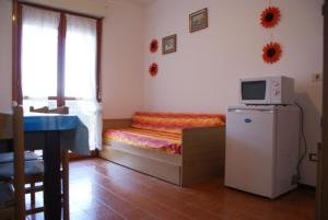 Kleines Zimmer mit einem Bett und einer Mikrowelle. in der Unterkunft Bibione getaway - comfy flat in residence in Bibione