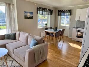 a living room with a couch and a table at Leilighet sentralt på Senja in Silsand