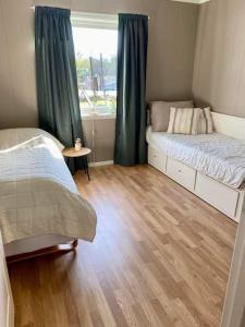 a small bedroom with two beds and a window at Leilighet sentralt på Senja in Silsand