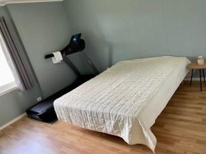 1 dormitorio con cama, mesa y ventana en Leilighet sentralt på Senja, en Silsand