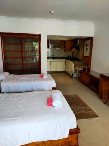 Herrmes Hostel في شرم الشيخ: غرفة نوم بسريرين عليها وسائد وردية