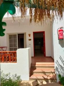 une maison blanche avec une porte rouge et des escaliers dans l'établissement Herrmes Hostel, à Charm el-Cheikh