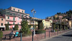 un grupo de personas sentadas en una acera en una ciudad en Casa Diana - ArgonautiVacanze, en Porto Azzurro