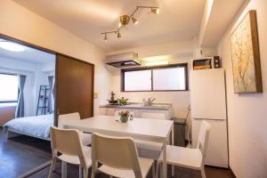 Il comprend une cuisine et une salle à manger avec une table et des chaises blanches. dans l'établissement Walk to Higashi-Nakano sta. COB3, à Tokyo