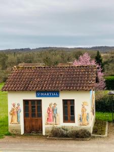 a small building with paintings on the side of it at Ancien Relais de Poste The Old Post Office in Saint-Martial-dʼAlbarède