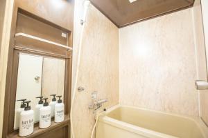 La salle de bains est pourvue d'une baignoire et de 3 bouteilles de savon. dans l'établissement Walk to Higashi-Nakano sta. COB3, à Tokyo