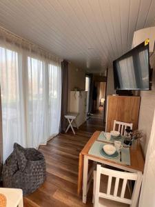 a living room with a table and a tv on the wall at Bibernest in Ziethen +34 photos