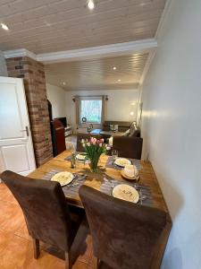 a dining room with a wooden table and chairs at Ferienhaus Lönnehus in Fehmarn