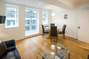 a living room with a table and chairs and windows at 1BD Modern City Oasis: Near London Attractions in London