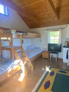 a bedroom with bunk beds and a flat screen tv at Ulvsby Ranch in Karlstad