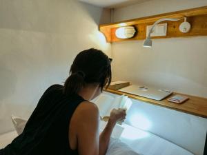 a woman sitting on a bed playing a video game at De Nata in Labuan Bajo +40 photos