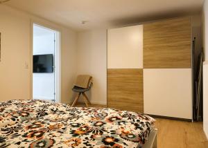 a bedroom with a bed and a tv and a chair at Rottweiler Ferienwohnung in Rottweil