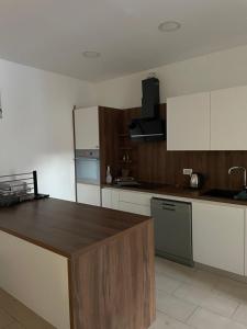 a kitchen with white cabinets and a wooden counter top at Guesthouse Stari Mayr in Kranj