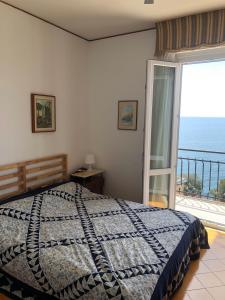 een slaapkamer met een bed en een groot raam bij DAVANTI AL MARE E A PORTOFINO - IN FRONT OF THE SEA AND PORTOFINO in Zoagli