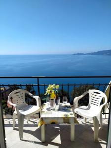 een tafel en stoelen op een patio met uitzicht op de oceaan bij DAVANTI AL MARE E A PORTOFINO - IN FRONT OF THE SEA AND PORTOFINO in Zoagli