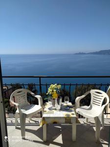 una mesa y sillas en un balcón con vistas al océano en DAVANTI AL MARE E A PORTOFINO - IN FRONT OF THE SEA AND PORTOFINO, en Zoagli