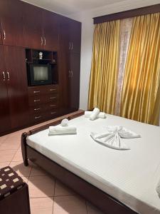 een slaapkamer met een groot bed en een televisie bij Villa Kevin's in Sarandë
