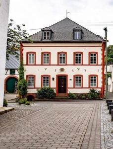 una gran casa roja y blanca en una calle de ladrillo en Komfort FeWo l Moselstay l maximal 4 Personen und Baby I Brauneberg Mosel I WIFI I, en Brauneberg