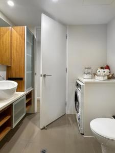 uma casa de banho com uma máquina de lavar roupa e um lavatório em CBD Penthouse View Apartment em Adelaide