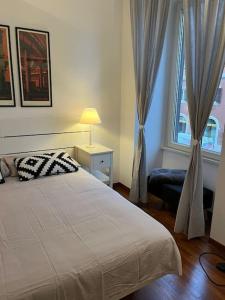 La casa di Monica appartamento Ostiense Roma في روما: غرفة نوم بسرير ابيض ونافذة