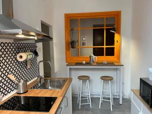 La casa di Monica appartamento Ostiense Roma في روما: مطبخ مع حوض ومكتب مع الكراسي