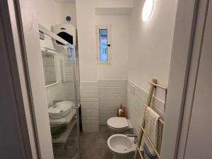 La casa di Monica appartamento Ostiense Roma في روما: حمام صغير مع دورتين مياه ومغسلة