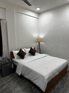 sypialnia z dużym łóżkiem z białą pościelą i poduszkami w obiekcie La Serene Inn w mieście Arambol