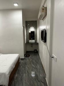 a room with a bed and a television and a sink at La Serene Inn in Arambol +2 photos