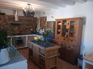 una cocina con armarios de madera y un jarrón de flores en Casa rural los Cerezos, en Albox