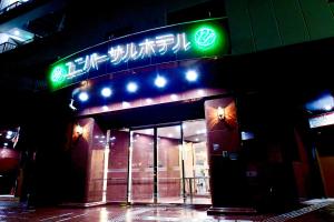 a building with a neon sign on top of it at Himeji Ekimae Universal Hotel Minamiguchi in Himeji