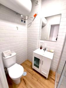 a bathroom with a toilet and a sink and a mirror at Enladrillada Apartment in Seville