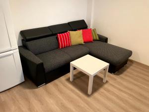 a living room with a black couch and a table at Útulný byt pro odpočinek i práci in Kutná Hora