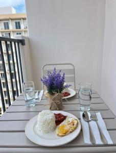 dos platos de comida en una mesa en un balcón en RichAirbnb Cebu, en Lapu Lapu City