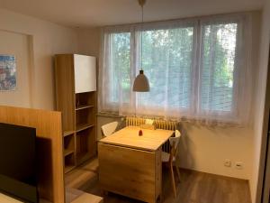 een woonkamer met een tafel en een groot raam bij Útulný byt pro odpočinek i práci in Kutná Hora