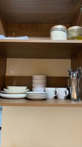 a shelf with plates and dishes on it at RichAirbnb Cebu in Lapu Lapu City