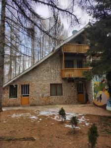 un edificio de piedra con balcón de madera. en Villa Rashkov, en Kočani
