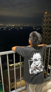 a man standing on a balcony looking at the city at RichAirbnb Cebu in Lapu Lapu City