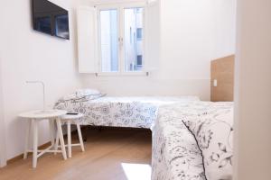 sypialnia z 2 łóżkami i małym stołem w obiekcie Stay In Rome w Rzymie