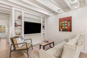 ein Wohnzimmer mit weißen Wänden und einem Flachbildfernseher in der Unterkunft Perfect Symmetry - 520 Beach - 4 Bedrooms in Demere Park