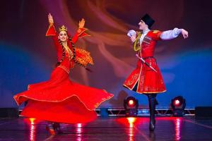 dois dançarinos em vestidos vermelhos dançando em um palco em Orbi City sea view em Batumi