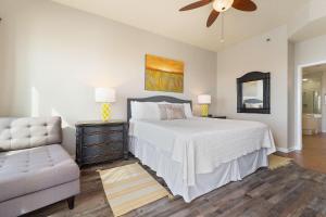 a bedroom with a bed and a couch and a ceiling fan at Seachase 1503W in Orange Beach +47 photos
