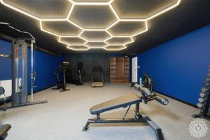 a room with a gym with a blue wall at Seaside Apartamenty WHITEBLUE I Kołobrzeg SAUNA & FITNESS & BAWIALNIA DLA DZIECI & ROWEROWNIA - w cenie pobytu in Kołobrzeg +72 photos