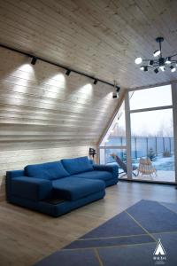 un soggiorno con divano blu in una camera di Rauda home a Uralʼsk