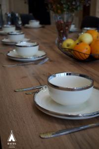 un tavolo in legno con piatti e ciotole di frutta di Rauda home a Uralʼsk