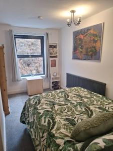 Walsden的住宿－Todmorden Bed & Breakfast - The Toothless Mog，一间卧室设有一张大床和一个窗户。