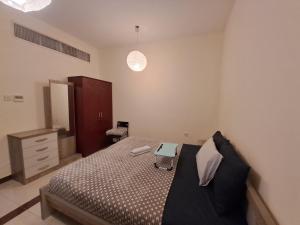 a bedroom with a bed and a dresser in it at Top House Zayed Airport in Abu Dhabi